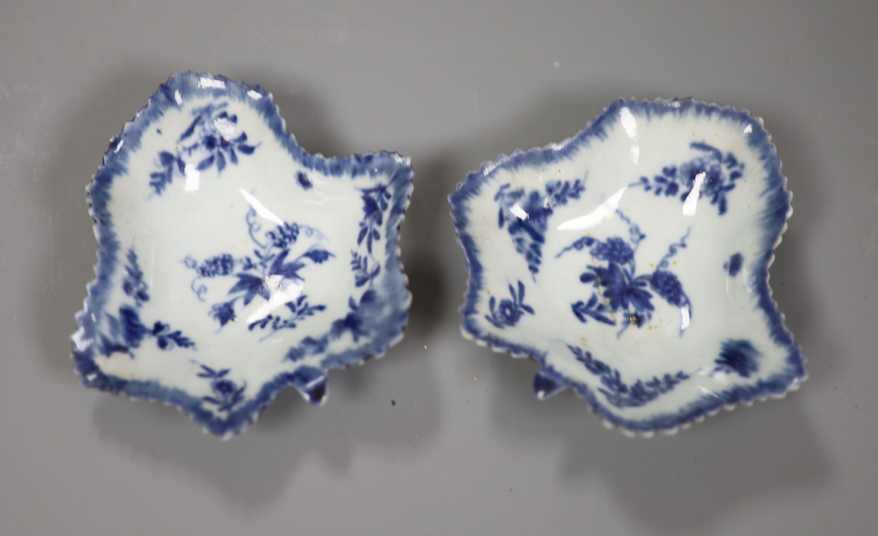 An 18th century Worcester pair of leaf-shaped pickle dishes painted in underglaze blue with a fruiting vine, one with workmans mark.